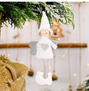 Detailed plush Christmas angel ornament with silver sequins on a snowy pine branch