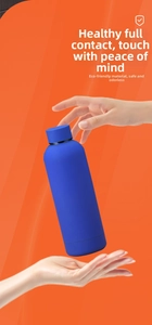 Tasse de voyage bleu foncé mat en acier inoxydable sur fond orange vif