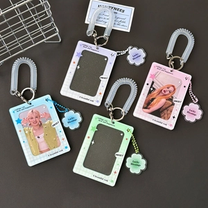 Four colorful acrylic photocard holders with glitter and cloud charms on grey background