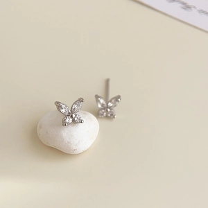Macro detail of silver butterfly studs with clear marquise zircon stones on stones