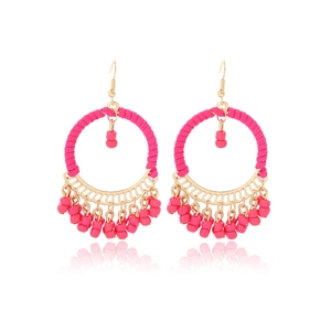 Detail of pink hand-woven fringe earrings with golden hoop and bohemian beads