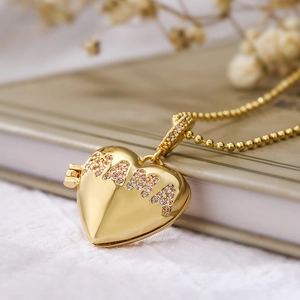 Golden heart locket necklace with pink crystal MAMA lettering on a bead chain