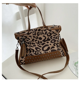 Detail of leopard print handbag featuring decorative metal studs and a leather tassel