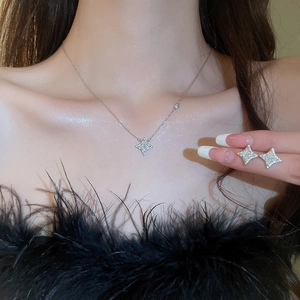 Sparkling silver star necklace and earrings set with zircons shown on a female model