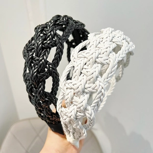Detail of twisted faux leather headbands in black and white colors with braided texture
