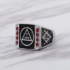 Macro detail of men's Masonic ring with red rhinestones and compass symbol on silver steel