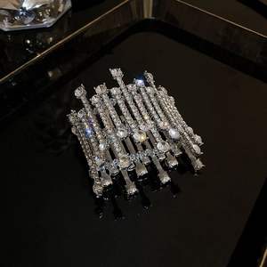 Macro shot of silver-tone wide cuff bracelet with dense clear crystals on black background