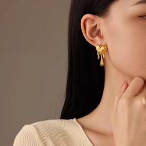 Elegant gold lava heart earrings with fluid teardrop design on model side profile