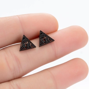 Detailed macro view of black triangular stud earrings with intricate floral cutouts