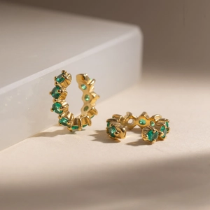 18K gold plated stainless steel ear cuffs featuring green zircon gemstones on white background
