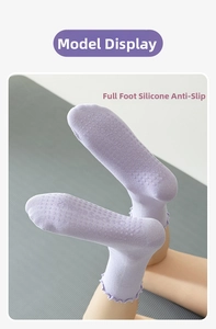 Detailed view of lavender yoga socks with non-slip silicone grip on light grey mat