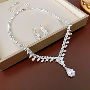 Close-up of sparkling silver zircon teardrop necklace and matching earrings in a jewelry box