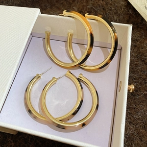 Detailed macro view of vintage tortoiseshell C-shape resin hoop earrings with gold metal