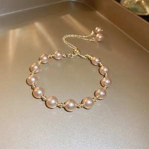 Detailed macro view of the vintage pearl bracelet with adjustable sliding gold clasp