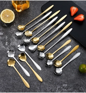 Flachbild von blumen- und herzförmigen Kaffeelöffeln aus Edelstahl in Gold und Silber