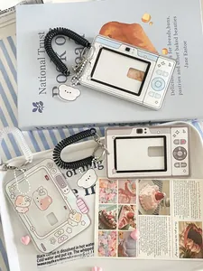 Macro view of retro camera and game console acrylic card holders with cute pendants