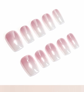Detailed view of 10-piece pink and white ombre press-on nails with a glossy finish