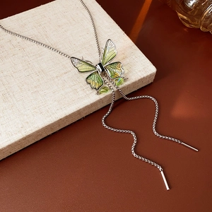 Detail of silver Y-shaped necklace featuring a lime green enamel butterfly and crystal