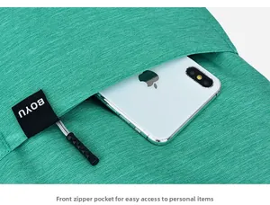 Detail view of a green fabric backpack front pocket showing practical phone storage space