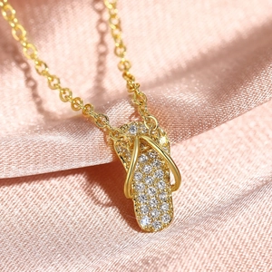 Creatieve gouden slipper ketting met schitterende zirkonia op een roze satijnen stof