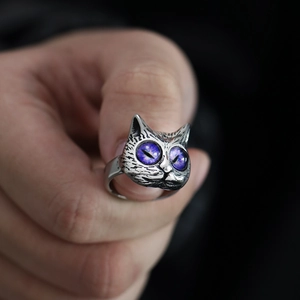 Close-up of vintage owl ring featuring detailed silver feathers and purple cosmic eyes
