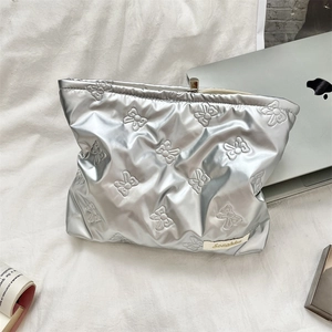 Silver quilted PU makeup bag with bow patterns and elegant metal frame clasp closure