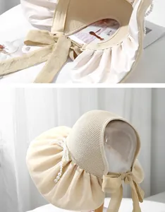 Detail of sun hat with straw brim, satin pleats, pearl beads and large bow ribbon
