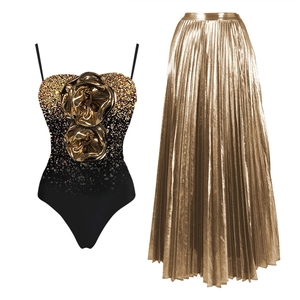 Black and gold sequin swimsuit with 3D floral accent and pleated metallic maxi skirt