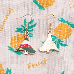 Detailed view of enamel Christmas tree earrings with festive red and green colors