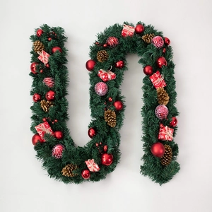 Christmas pine needle garland with red baubles, gift boxes and gold pinecones on white background