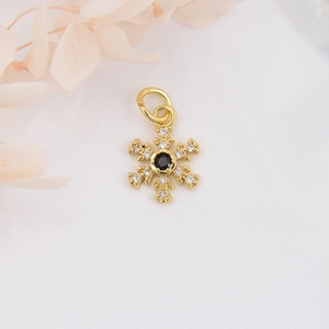 Macro shot of 18k gold plated snowflake pendant with black and clear zircon crystals
