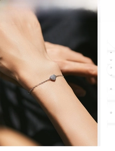 Macro detail of S925 sterling silver heart bracelet featuring pavé set sparkling cubic zirconia