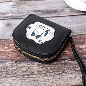 Detail of a black PU leather small wallet with cartoon cat pattern and gold zipper