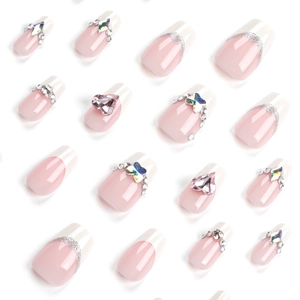 French press-on nails with pink hearts and sparkling rhinestones on white background