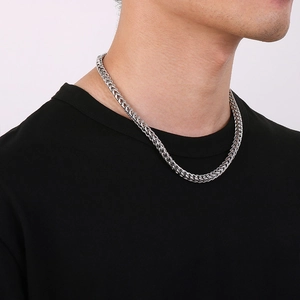 Close-up of thick silver dragon bone chain necklace on a black t-shirt for men