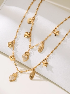 Detail of vintage 18k gold plated necklaces with heart, star and virgin mary pendants
