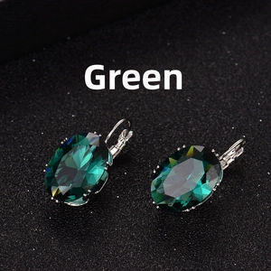 Detail of oval-cut peacock green crystal earrings with elegant French hooks on black base