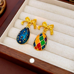 Dettaglio di collane vintage con fiocco dorato e pendenti in smalto blu e a scacchi colorati
