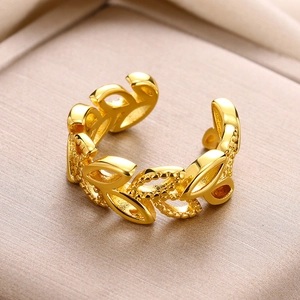Macro shot of gold adjustable open ring featuring hollow leaf patterns and milgrain edges