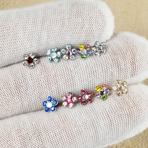 Detail view of flower-shaped 316L stainless steel ear studs in nine assorted colors