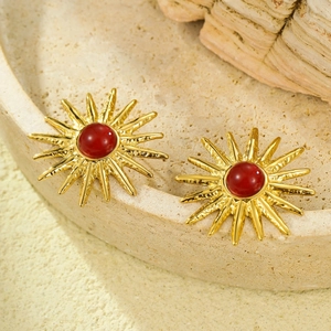 Detail of vintage gold sunflower stud earrings with red round natural stone inlay