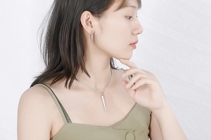 Close-up of model wearing silver stainless steel spiral cone necklace and earrings set