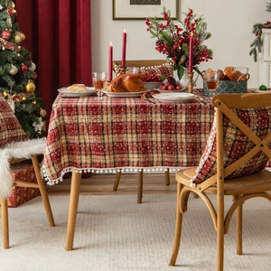 Christmas plaid tablecloth with white snowflakes and pom-pom trim in a cozy festive setting