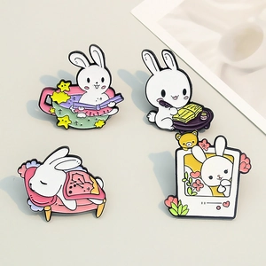 Set of 4 cute white bunny enamel pins showing reading, writing and sleeping activities