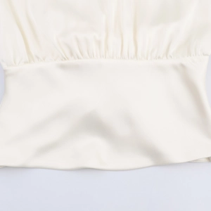 Elegant cream satin blouse featuring detailed waist pleats and smooth silk texture