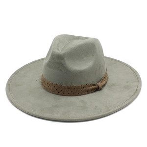 Détail d'un chapeau fedora en daim à large bord avec ruban à pois marron et décoration