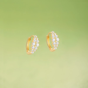 Detailed close-up of gold-plated silver hoop earrings with pavé-set clear cubic zirconia