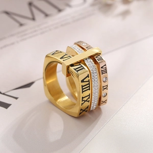 Dettaglio di anelli sovrapponibili con numeri romani e cristalli in oro e rosa
