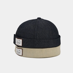 Stacked dark blue denim and beige cotton docker hats showing detailed fabric texture