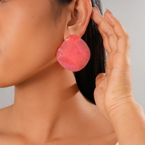 Detailed close-up of pink resin geometric earring featuring fine textured finish